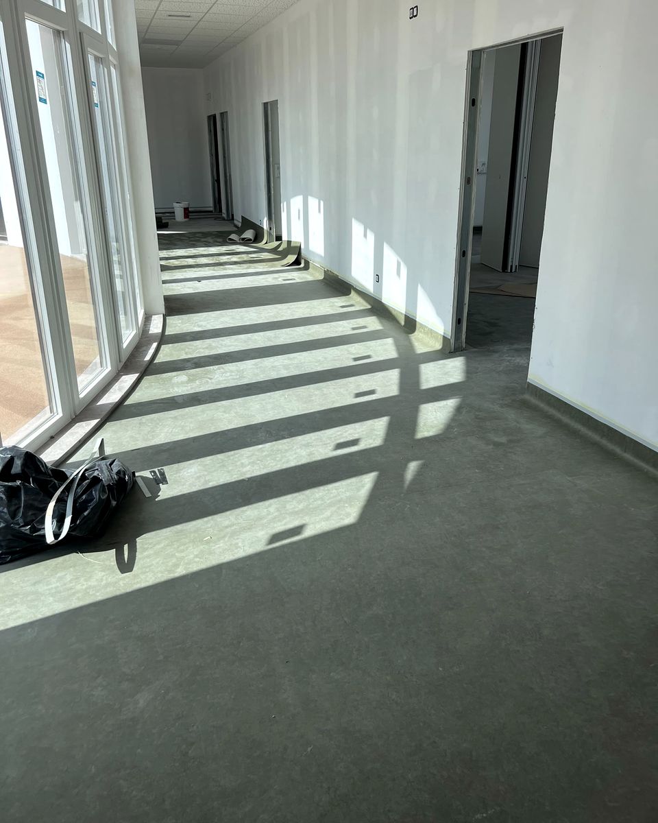 Sala com pavimento em rolo verde e luz de janela